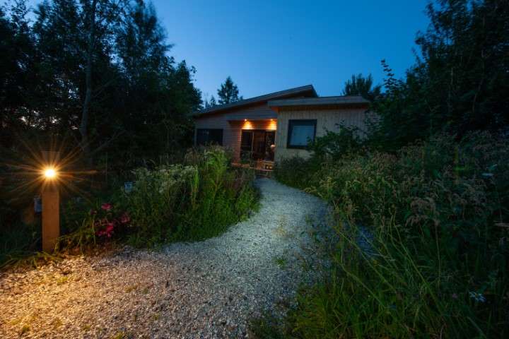 Beleuchteter Kiesweg zur Wasserlodge Ljurk am Abend