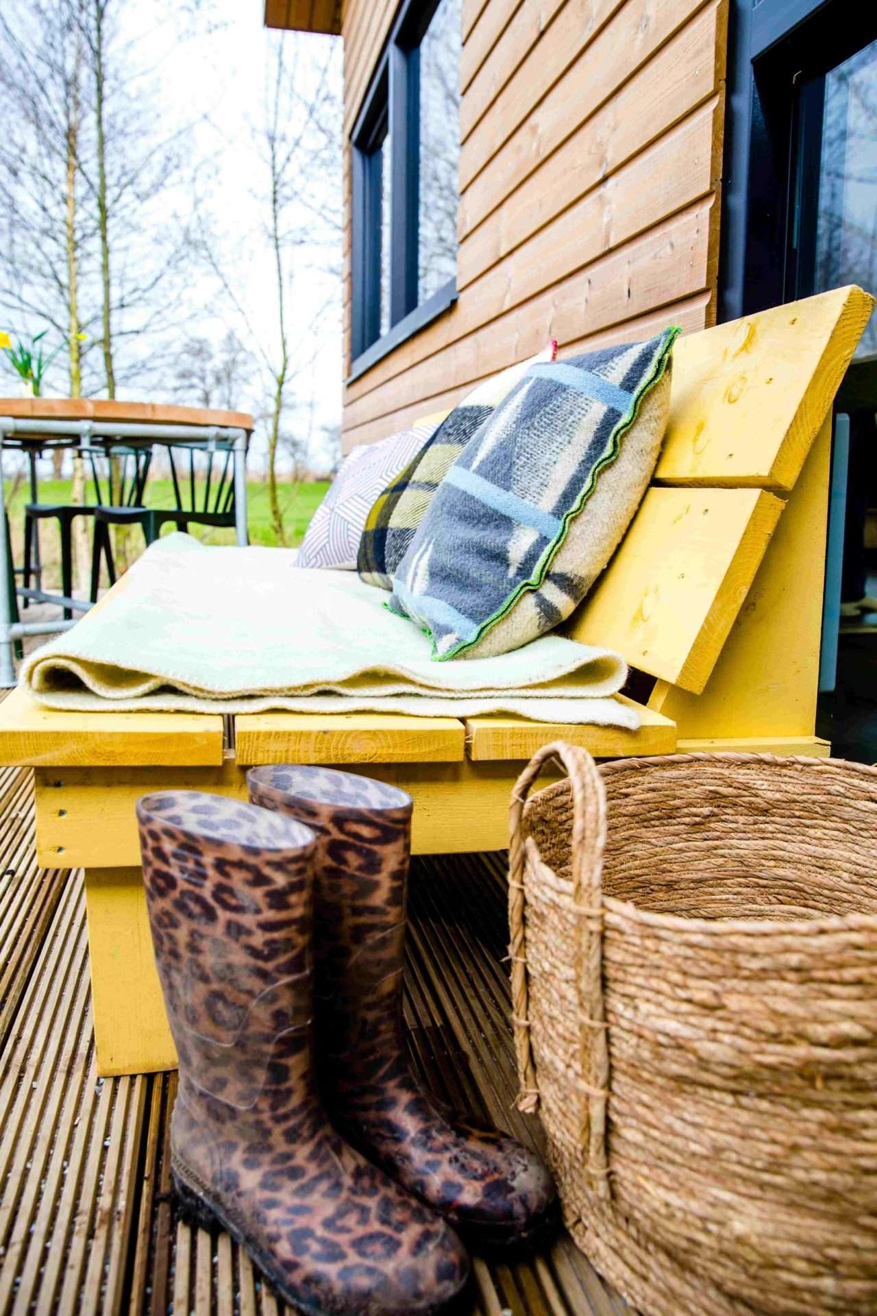 Gelber Gartenstuhl und Stiefel auf der Terrasse der Waterlodge Ljurk